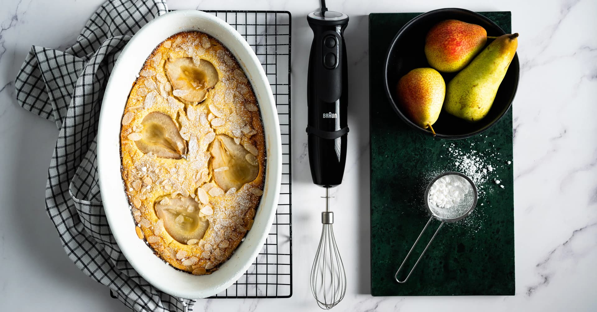 Mixeur plongeant Braun MultiQuick avec son fouet, à côté d'un clafoutis aux poires